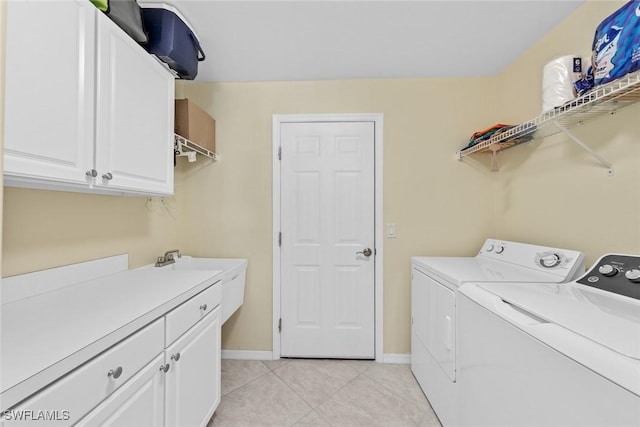 laundry room featuring light tile patterned floors, independent washer and dryer, cabinet space, and baseboards