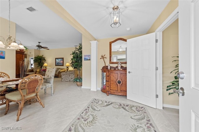 entrance foyer with light tile patterned floors, baseboards, visible vents, and ceiling fan with notable chandelier