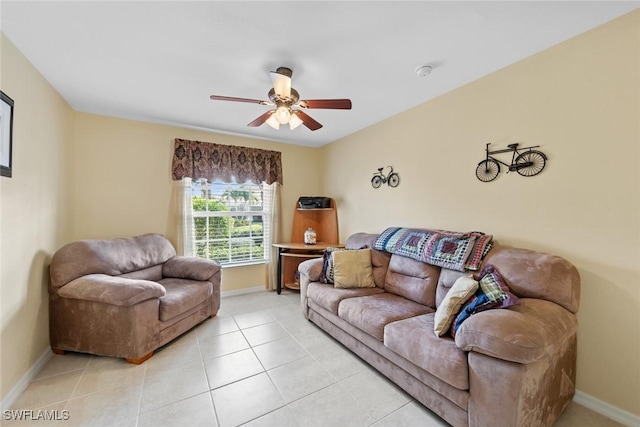 living area with ceiling fan, baseboards, and light tile patterned flooring