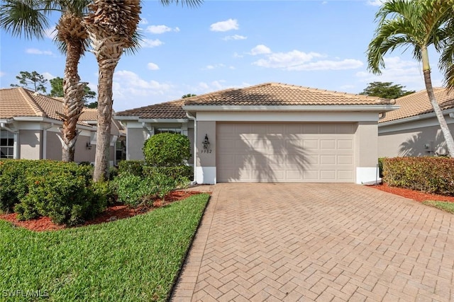 view of front of house featuring decorative driveway, a tiled roof, and stucco siding