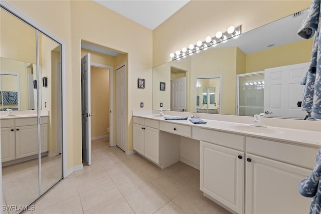 bathroom featuring double vanity, a sink, toilet, and tile patterned floors