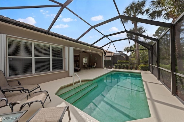 outdoor pool with glass enclosure and a patio