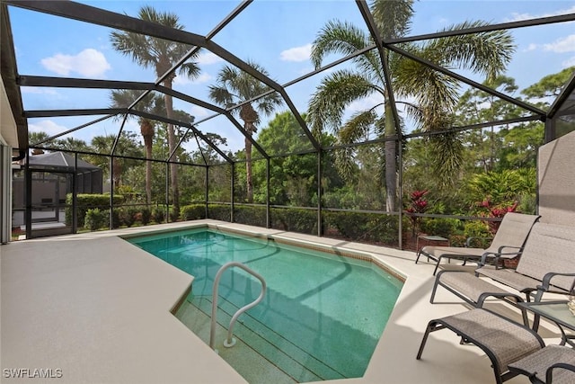 outdoor pool featuring glass enclosure and a patio