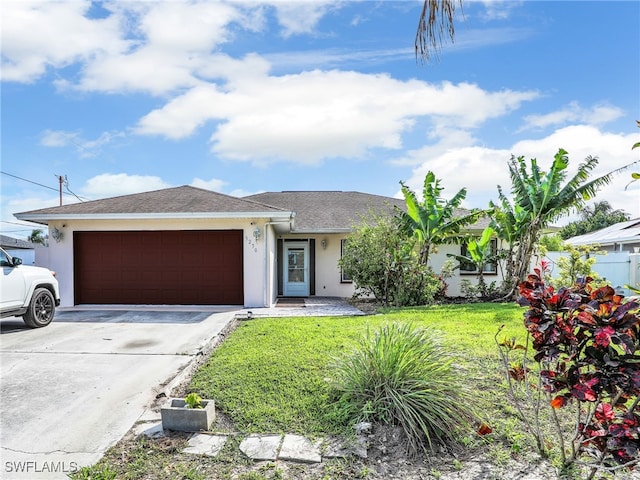 view of front of property with an attached garage, driveway, a front lawn, and stucco siding