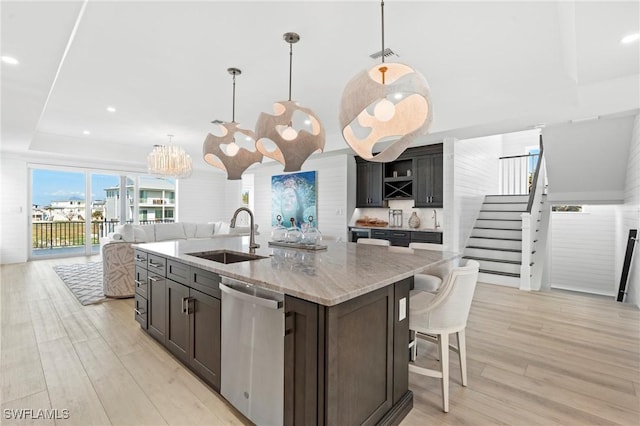 kitchen featuring a sink, visible vents, stainless steel dishwasher, open shelves, and light wood finished floors