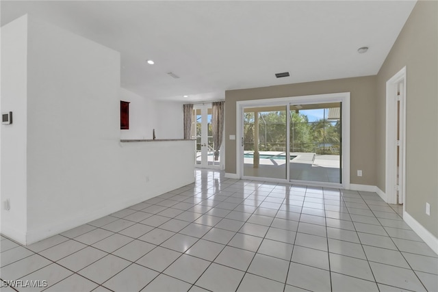 empty room with french doors, recessed lighting, visible vents, light tile patterned flooring, and baseboards