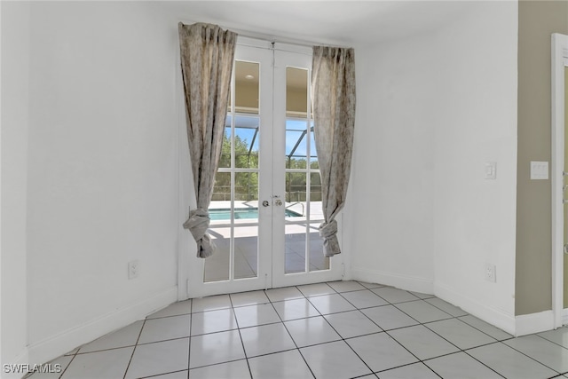 interior space featuring baseboards, french doors, and light tile patterned flooring