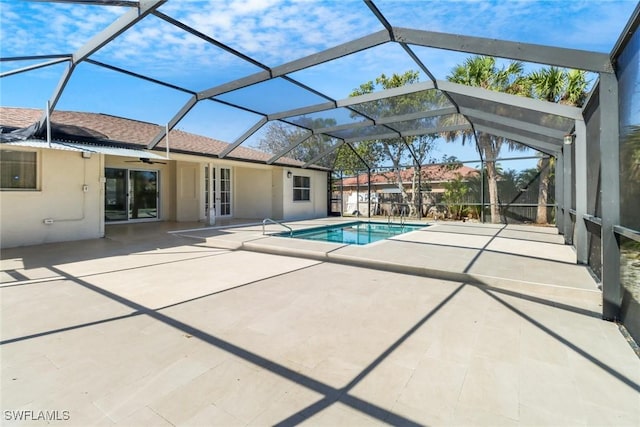 outdoor pool with ceiling fan, glass enclosure, french doors, and a patio