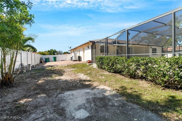 view of yard with a lanai and a fenced backyard