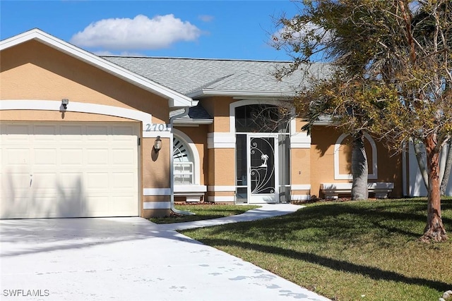 view of front facade with a garage, a shingled roof, driveway, stucco siding, and a front yard