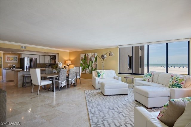 living room with crown molding, a water view, a beach view, and visible vents