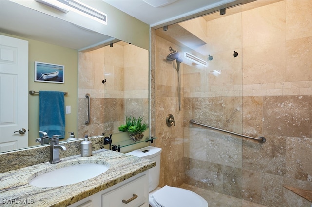 bathroom featuring vanity, a tile shower, and toilet