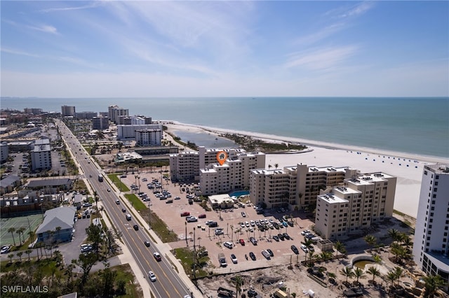 drone / aerial view with a water view, a city view, and a view of the beach