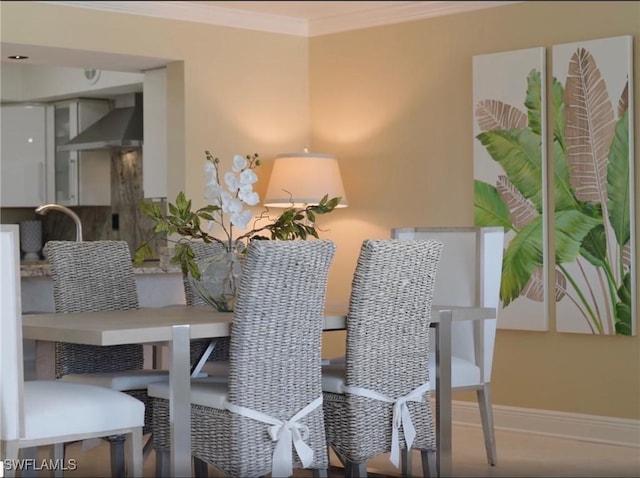 dining space featuring baseboards and crown molding