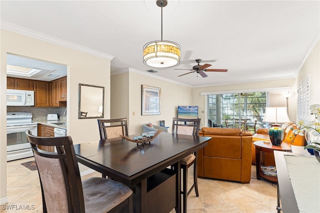 dining room with light tile patterned flooring, a skylight, visible vents, a ceiling fan, and crown molding