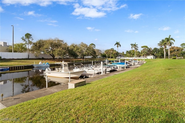 view of dock featuring a water view and a yard