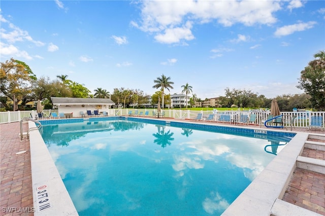 pool with a patio and fence