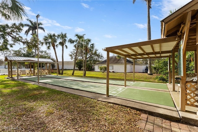 view of home's community with shuffleboard and a yard