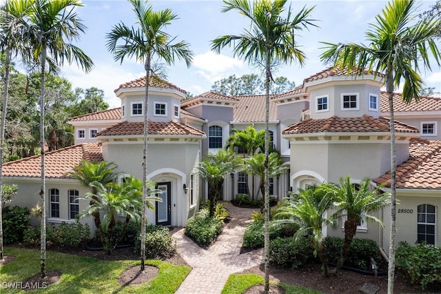 mediterranean / spanish-style home with a tiled roof and stucco siding