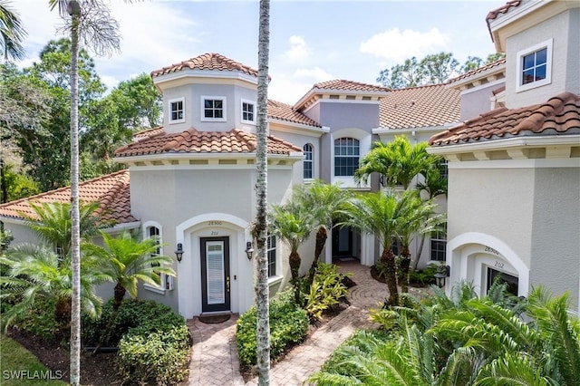 mediterranean / spanish-style home with a tiled roof and stucco siding