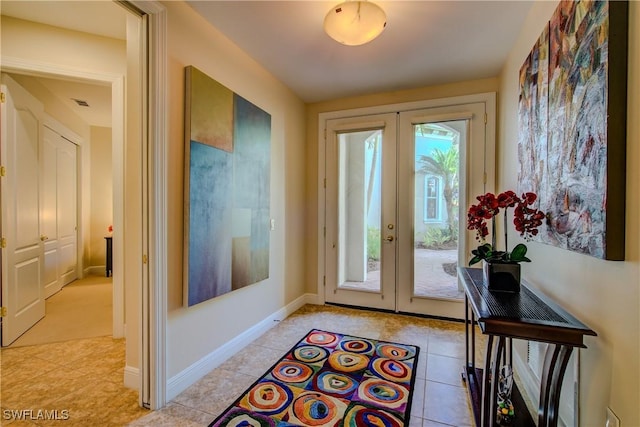 doorway featuring french doors, light tile patterned flooring, and baseboards