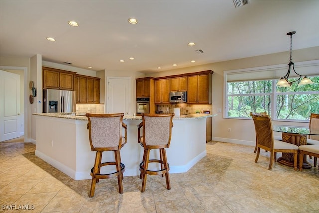 kitchen featuring appliances with stainless steel finishes, brown cabinetry, light stone counters, and decorative backsplash