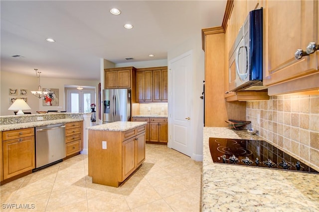 kitchen featuring a center island, recessed lighting, backsplash, appliances with stainless steel finishes, and brown cabinetry