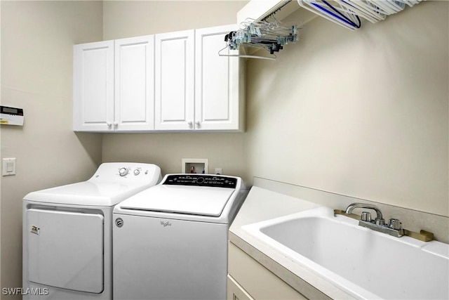 clothes washing area featuring cabinet space, separate washer and dryer, and a sink