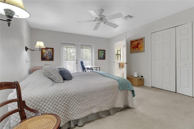 bedroom with visible vents, light colored carpet, ceiling fan, french doors, and a closet