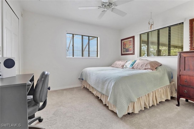 bedroom with light carpet, ceiling fan, and baseboards