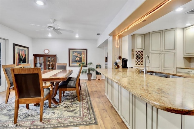 dining area with light wood-style flooring, indoor wet bar, and recessed lighting