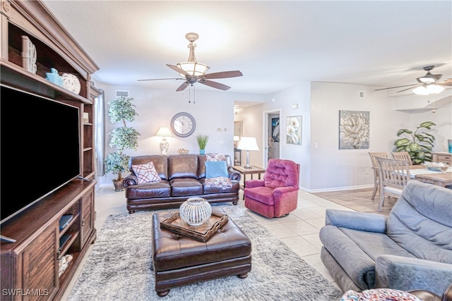 living room with visible vents, ceiling fan, baseboards, and light tile patterned floors