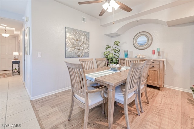 dining room featuring light wood-type flooring, baseboards, visible vents, and ceiling fan