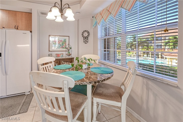 dining room featuring baseboards, a notable chandelier, and light tile patterned flooring