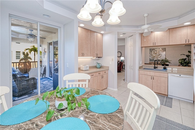 kitchen featuring decorative light fixtures, light countertops, light brown cabinets, a sink, and white dishwasher