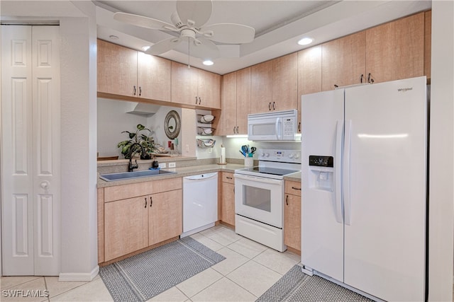 kitchen featuring white appliances, light tile patterned floors, light countertops, and a sink