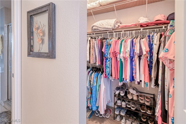 walk in closet with wood finished floors