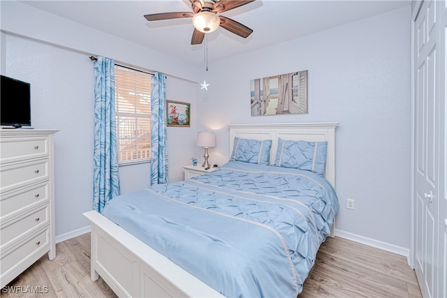 bedroom featuring baseboards, ceiling fan, and light wood-style floors