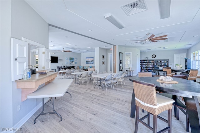 dining space with ceiling fan, visible vents, light wood-style flooring, and baseboards