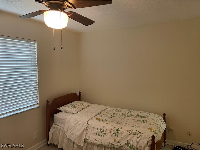 bedroom with a ceiling fan and baseboards