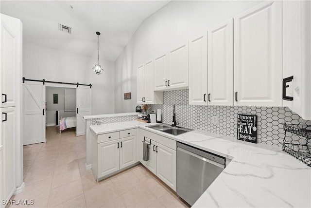 kitchen featuring white cabinets, dishwasher, a sink, and a barn door