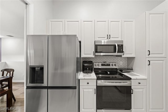 kitchen with appliances with stainless steel finishes, light countertops, and white cabinets