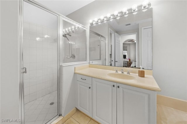 ensuite bathroom featuring a stall shower, tile patterned floors, vanity, and ensuite bathroom