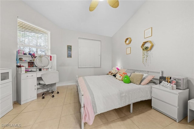 bedroom with lofted ceiling, ceiling fan, light tile patterned floors, and baseboards