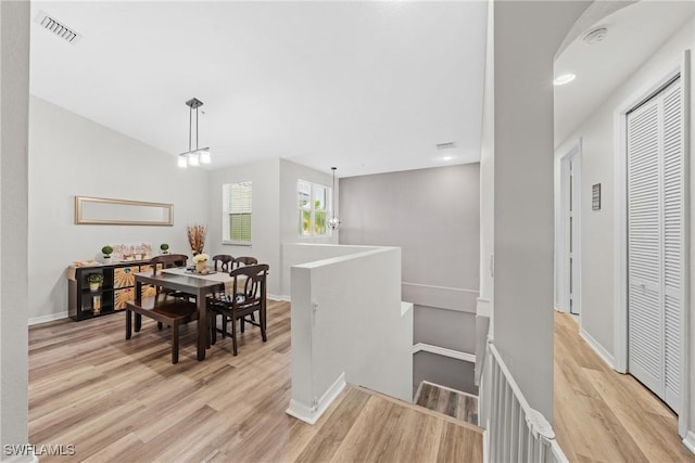 dining area featuring light wood-type flooring, visible vents, and baseboards