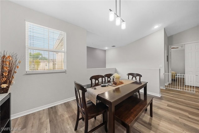 dining space with baseboards, wood finished floors, and recessed lighting