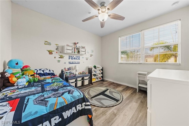 bedroom featuring baseboards, a ceiling fan, and wood finished floors