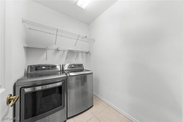 washroom featuring laundry area, light tile patterned floors, baseboards, and independent washer and dryer