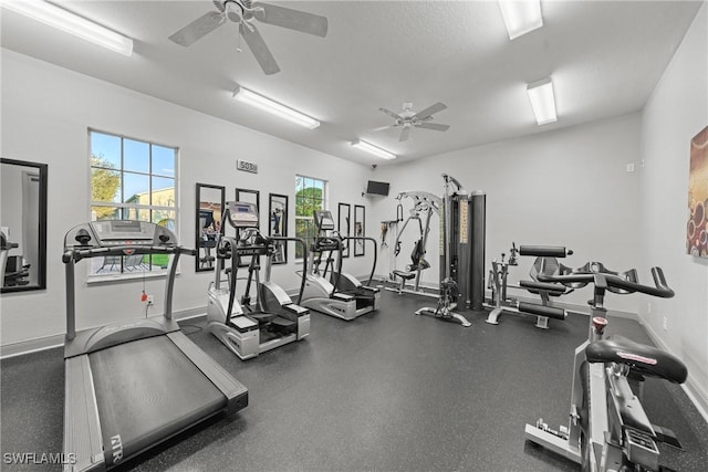 workout area featuring a ceiling fan and baseboards