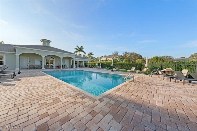 community pool featuring a patio area and fence